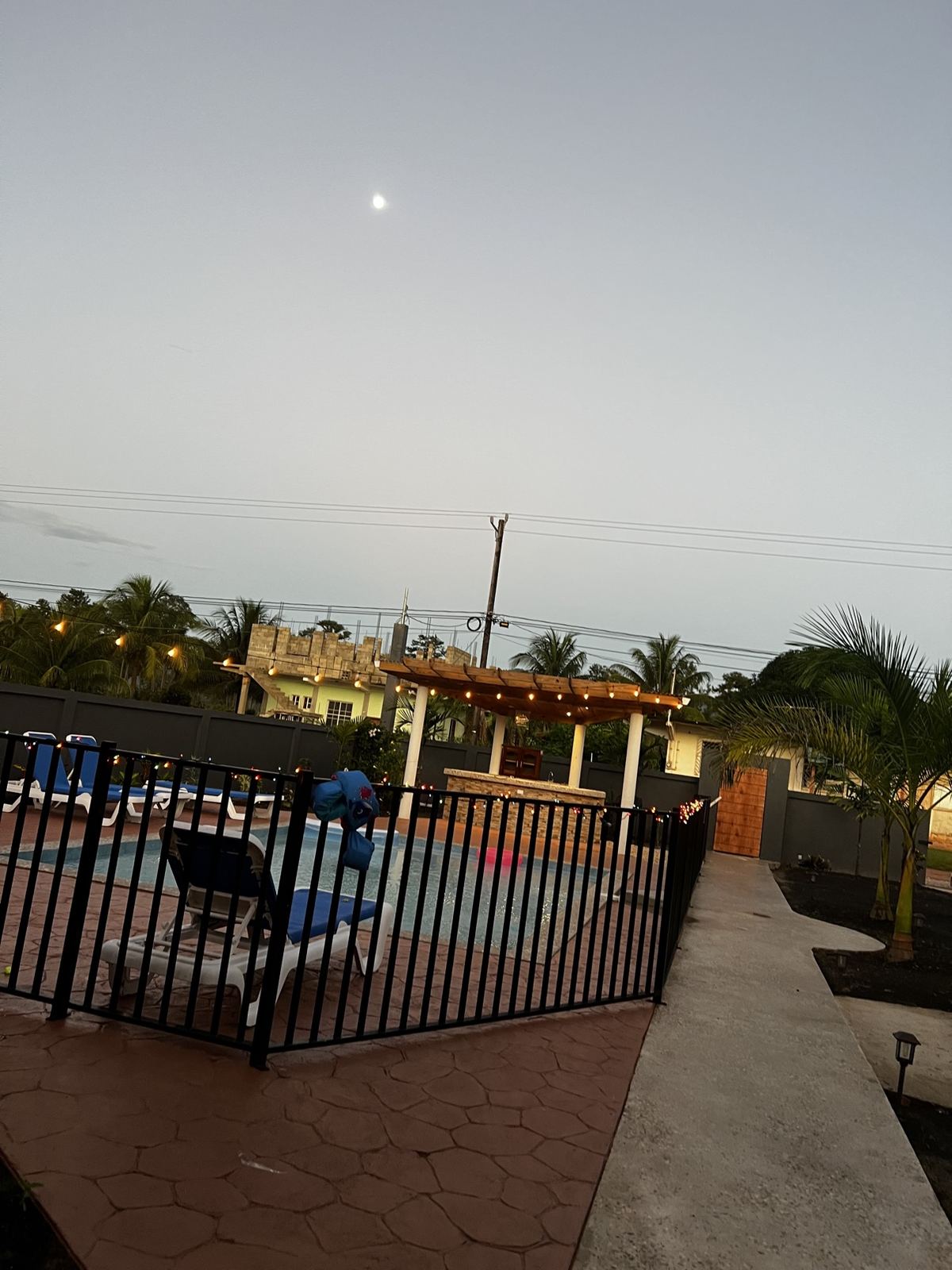 Paradise Palms pool area glowing under string lights at dusk