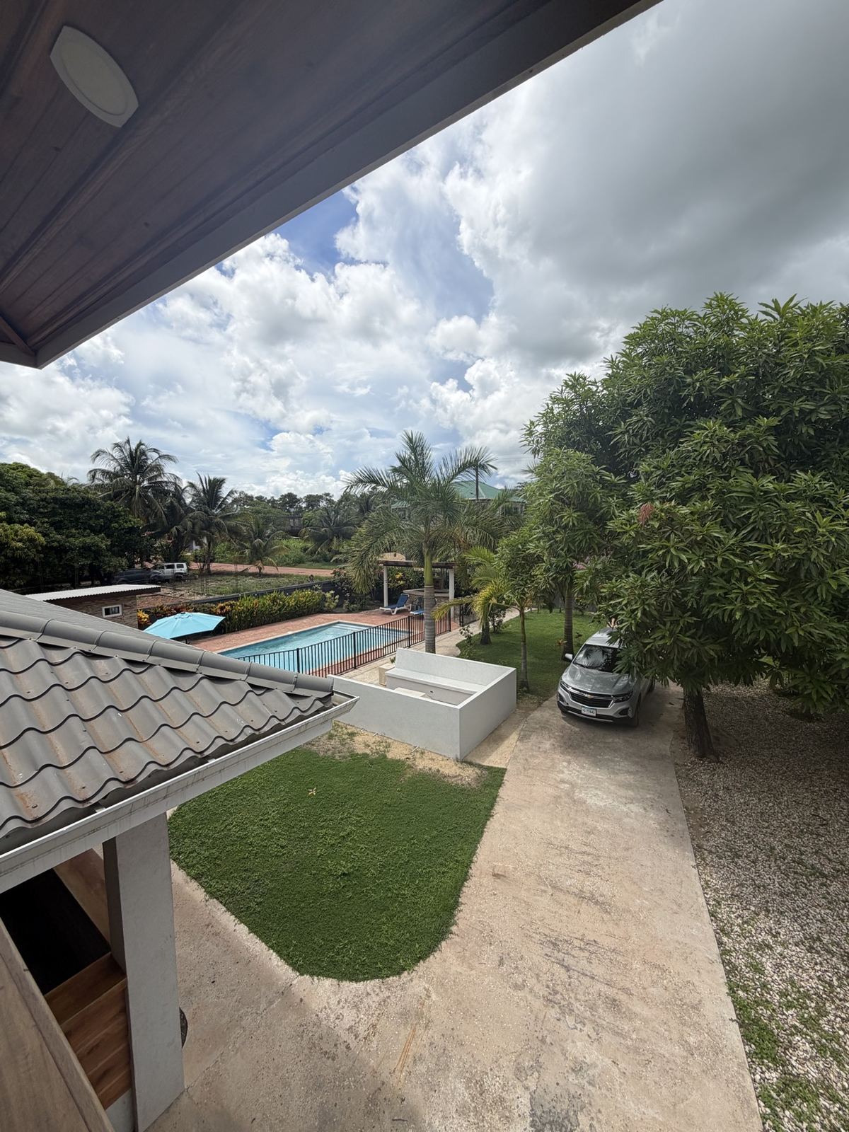 Elevated balcony view over the Paradise Palms pool, lawn and driveway